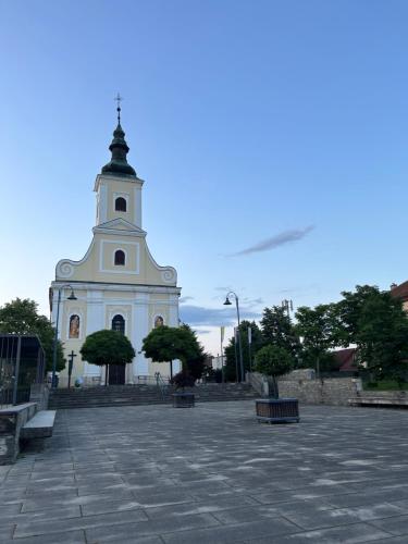 a large white building with a clock tower at Apartman ZABOK CENTAR in Zabok