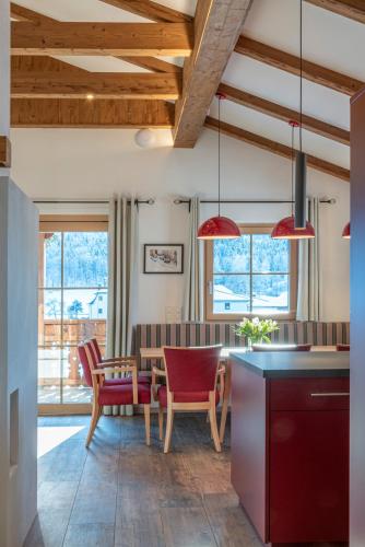 a kitchen and dining room with red chairs and a table at Villa Elisabeth in Strobl