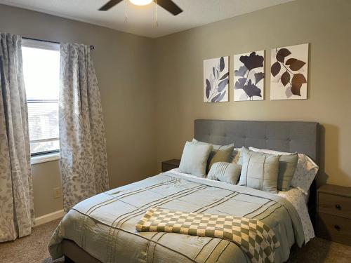 Schlafzimmer mit einem Bett und einem Fenster in der Unterkunft Charming Condo Near WFU, Full Kitchen, Strong WiFi in Winston-Salem