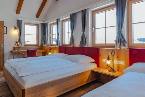 two beds in a room with windows at Villa Elisabeth in Strobl