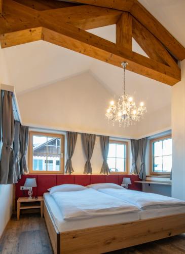 a bedroom with a large bed and a chandelier at Villa Elisabeth in Strobl