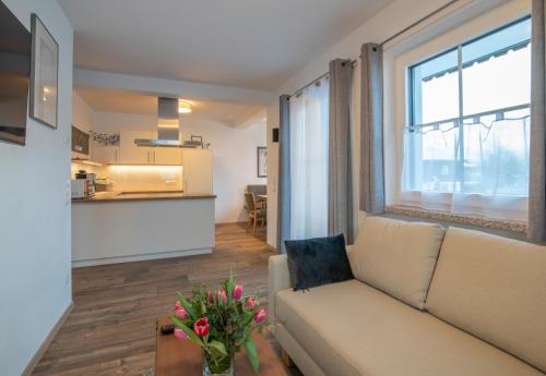 a living room with a couch and a table with flowers at Villa Elisabeth in Strobl