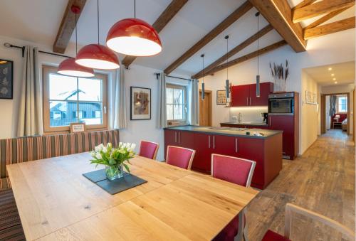 a kitchen and dining room with a wooden table and red cabinets at Villa Elisabeth in Strobl
