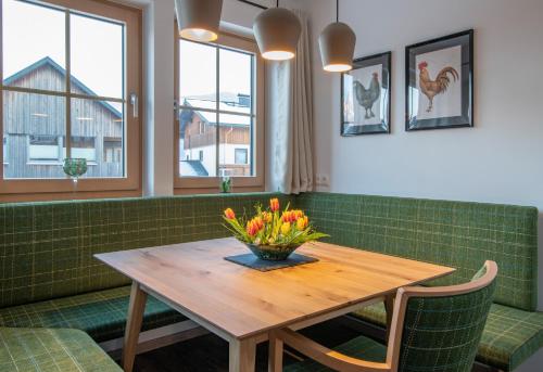 a dining room with a wooden table with flowers on it at Villa Elisabeth in Strobl