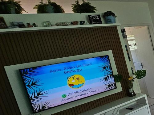 a flat screen tv sitting on top of a shelf at Bertioga Praia do SESC - Apartamento de 2 quartos in Bertioga