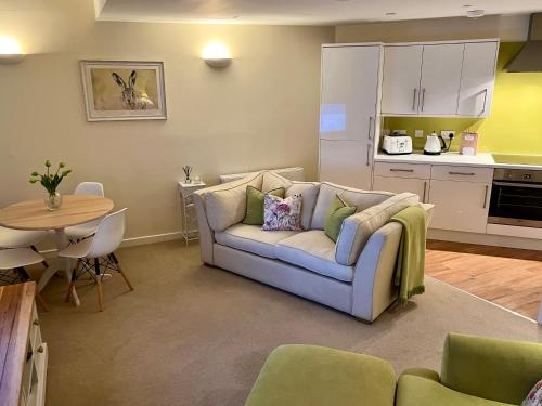 un soggiorno con divano e tavolo di WEE SUZIE STAYS - Stunning George St Apartment a Perth
