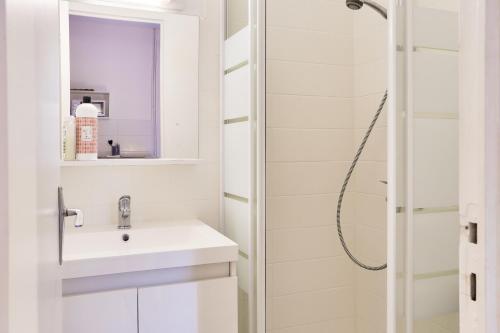 une salle de bain blanche avec un lavabo et une douche dans l'établissement Charmant Studio proche parc du Thabor et centre, à Rennes