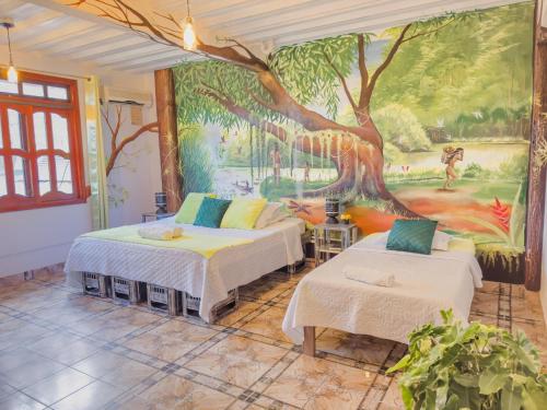 una camera con due letti e un dipinto sul muro di Eco Hotel El Refugio de La Floresta a Leticia