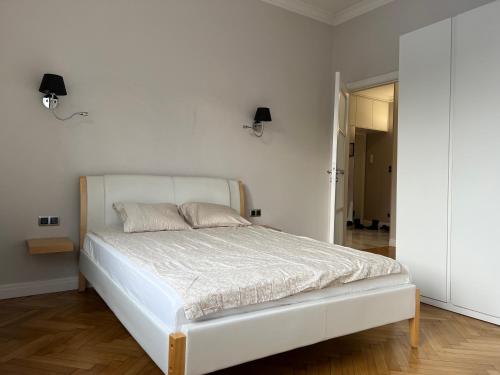 a white bed in a bedroom with a white wall at Apartament Wólczańska w stylu nowojorskim in Łódź