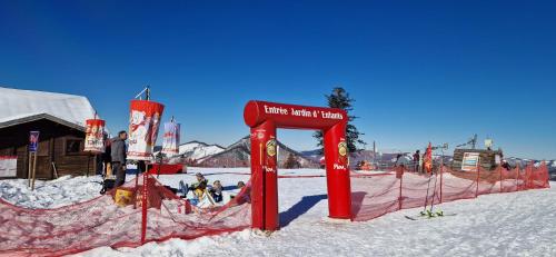a ski resort with a red sign in the snow at Le Chaleureux Cocon Rouge in Ustou