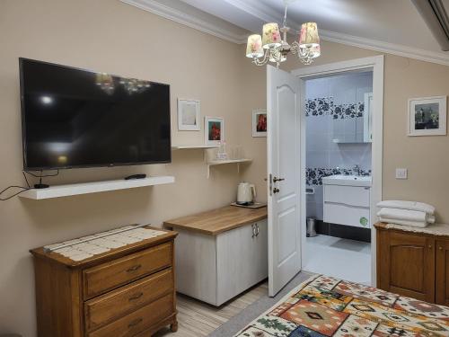 uma sala de estar com uma televisão de ecrã plano na parede em Hotel Odeon em Plovdiv