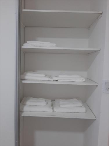 einen weißen Schrank mit weißen Handtüchern auf Regalen in der Unterkunft DPTO Bahia in Bahía Blanca