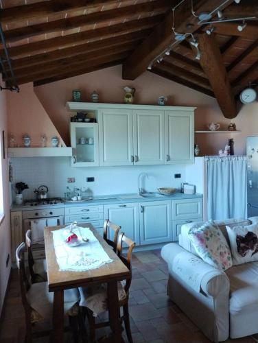 a kitchen with a table and a couch in a kitchen at Appartamento Olivella in Reggello