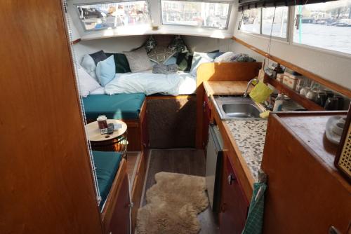 een kleine keuken met een bed en een wastafel in een boot bij Join boathotel in Amsterdam