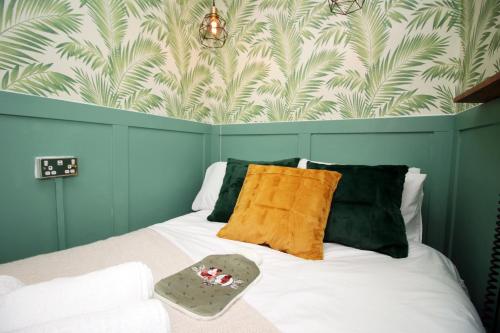 a bedroom with a bed with a green and white wall at Studio Apartment 5 mins walk to city, FREE WIFI AND PARKING in Cardiff
