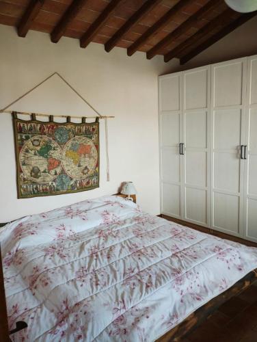a bedroom with a bed and a tapestry on the wall at Appartamento Olivella in Reggello