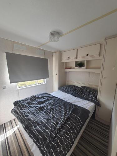 1 dormitorio con cama y ventana grande en Mobilheim v LVA 2 en Podivín