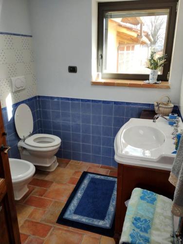 a bathroom with a toilet and a sink and a window at Appartamento Olivella in Reggello