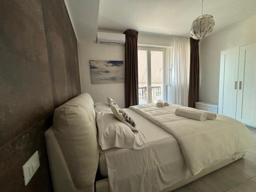 ein Schlafzimmer mit einem großen Bett und einem Fenster in der Unterkunft Appartamento Suite Galatea in Pozzallo