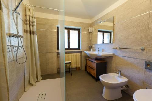 a bathroom with a sink and a toilet and a shower at Hotel Park Oasi in Arta Terme