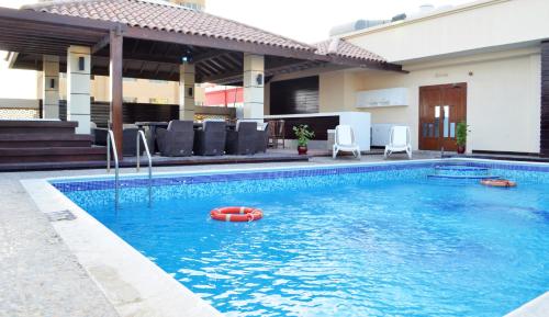 una piscina con una balsa roja en el agua en Kiev Tower Hotel Apartments, en Manama