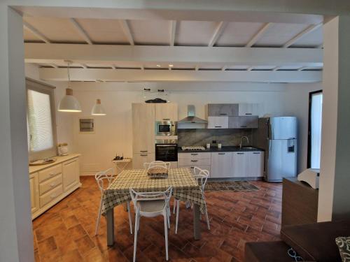 Private villa relax 2 &spa في Borgetto: مطبخ مع طاولة وكراسي في غرفة