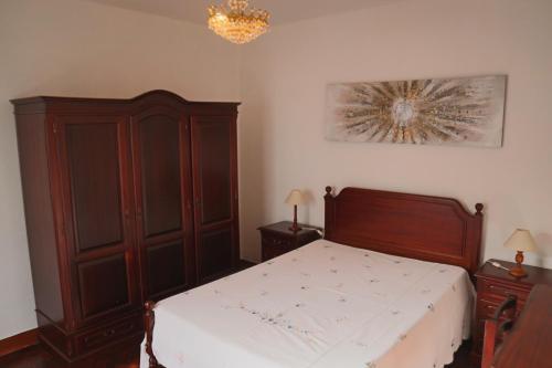 a bedroom with a bed and a wooden cabinet at Fifty's House 2 in Ribeira Brava