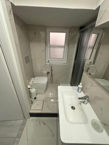 Baño blanco con lavabo y aseo en Appartamento suite Anfitrite, en Pozzallo