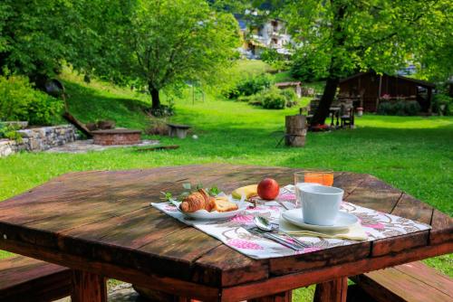 a wooden table with a plate of food on it at Hotel Park Oasi in Arta Terme