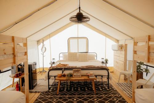 a bedroom in a tent with a bed and a table at Deluxe Glamping Tents at Lake Guntersville State Park in Guntersville
