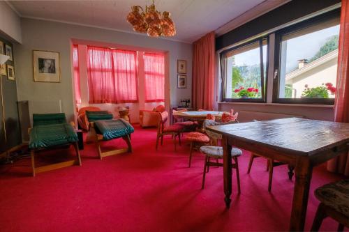 a room with a table and chairs and windows at Hotel Park Oasi in Arta Terme
