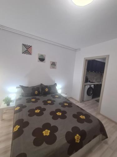 a bedroom with a bed with a black comforter with flowers at Siriului Studio in Bucharest
