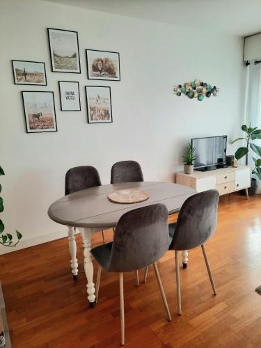 een eettafel met 4 stoelen en een televisie bij Beautiful & cosy apartment - La Défense in Courbevoie