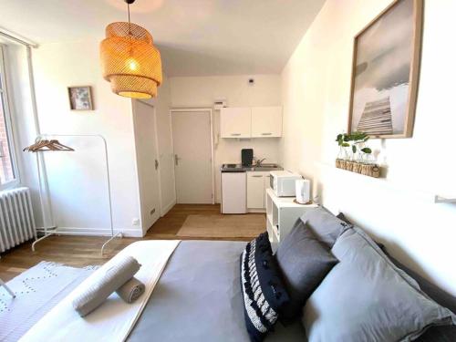 un salon avec un lit et une cuisine dans l'établissement Charmant studio au calme proche centre ville, à Rennes