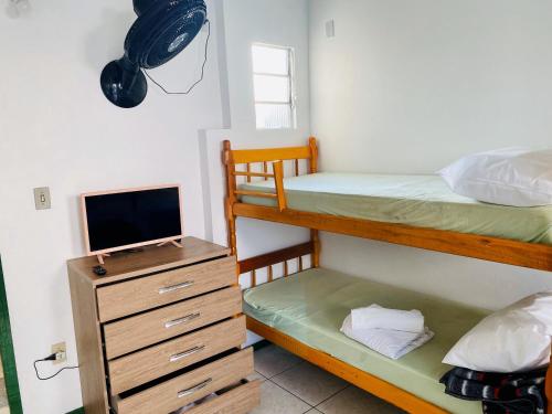 - une chambre avec 2 lits superposés et une télévision dans l'établissement Parada da Cal Beach Torres, à Torres