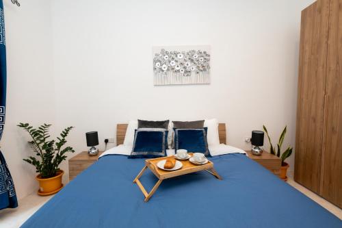 una camera con un letto blu e un vassoio di Chic 1BR Retreat in St Julian's a San Giuliano