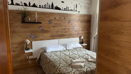 una camera con letto e parete con farfalle di Casa Gemelli a Roma