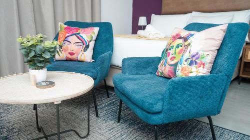 Omi’s Wholesome Apartment في امتاتا: غرفة بها كرسي ازرق وطاولة وسرير