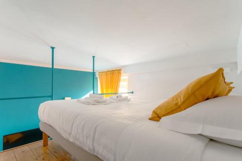 um quarto com uma cama branca e uma parede azul em Babuino Mini Loft em Roma