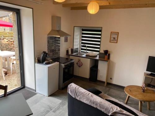 a living room with a couch and a kitchen at La boulangerie in Le Rozel