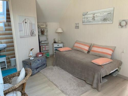 a bedroom with a bed with orange pillows on it at Capucine in Noyen-sur-Sarthe