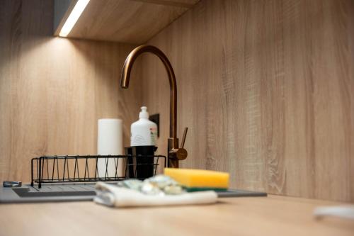 a counter with a sink with a toothbrush and a bottle of soap at Raspberry apartment and SPA in Dziwnów