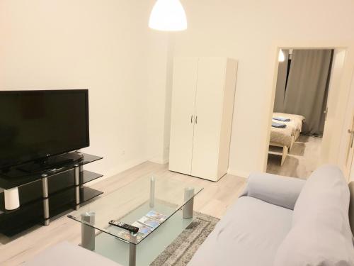 sala de estar con sofá blanco y TV en Ferienwohnung Kleopatra Messe Maschsee en Hannover