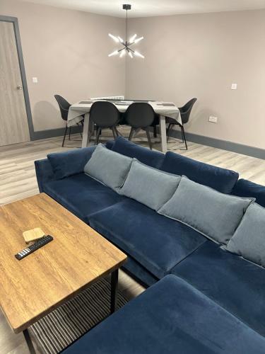 a living room with a blue couch and a table at NEW HAVEN APARTMENTS IN THE CENTRE. in Boston