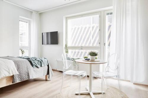 een slaapkamer met een bed en een tafel en stoelen bij Beautiful apartment in the center of Tampere in Tampere