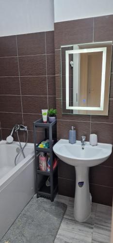 een badkamer met een wastafel, een spiegel en een bad bij Titan 4 Residance in Boekarest