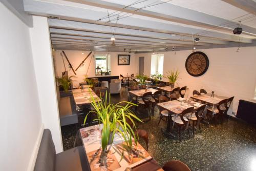 ein Restaurant mit Tischen und Stühlen und einer Uhr an der Wand in der Unterkunft Hôtel Le Chinfrey in Les Gets