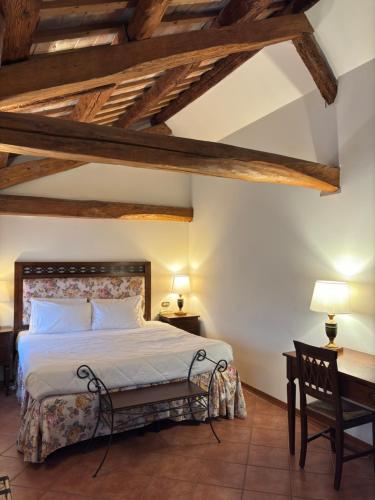 a bedroom with a bed and a table and a chair at Hotel Villa Luppis in Pasiano di Pordenone