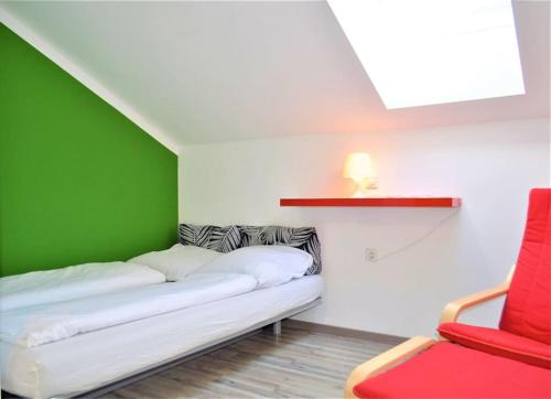 a green and white room with a couch and a red chair at Genuss Appartement am Familien Weingut in Krottendorf bei Ligist