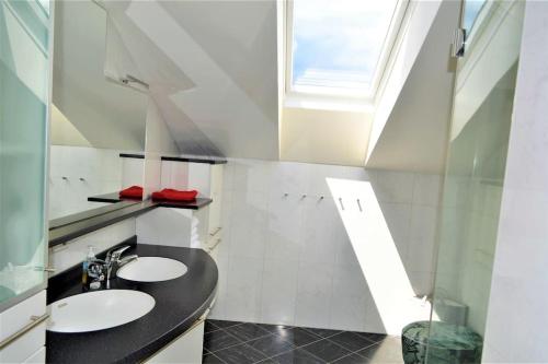 a bathroom with two sinks and a skylight at Genuss Appartement am Familien Weingut in Krottendorf bei Ligist